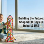 A child building with colorful STEM magnetic blocks in an apartment overlooking the Dubai Creek Harbour skyline, illustrating where to shop stem toys in the UAE.