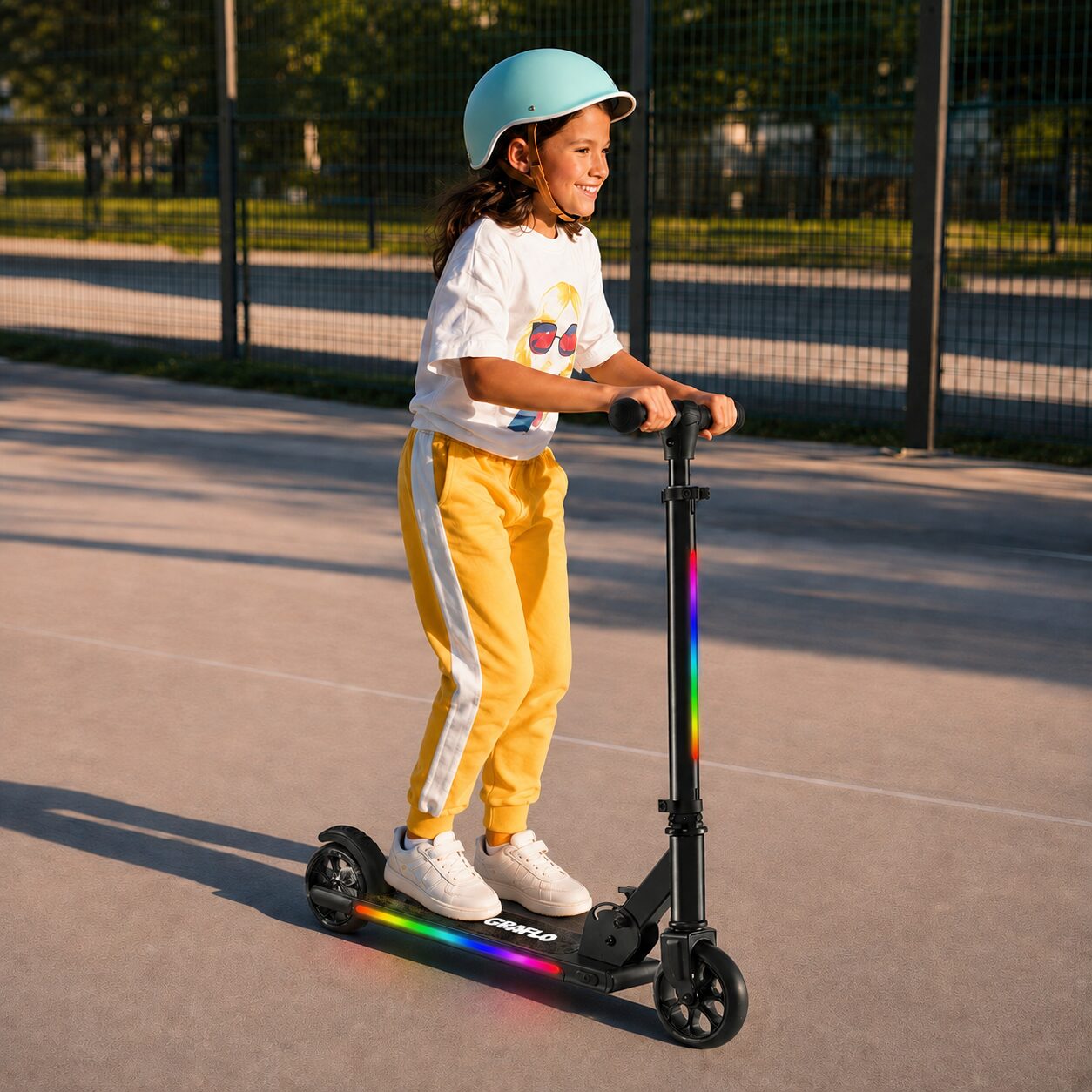 A girl riding the GRAFLO LED kick scooter along a park path