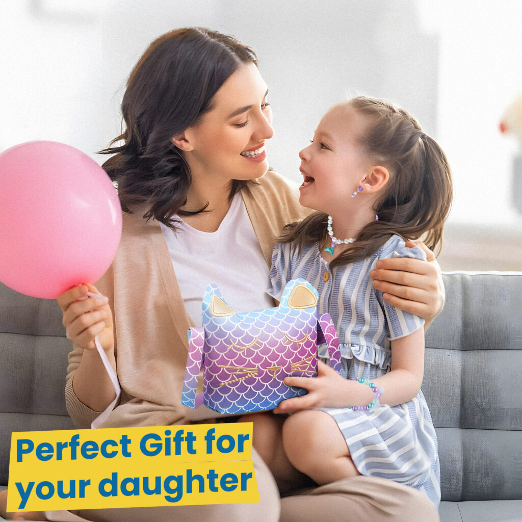 A mother and daughter on a sofa with a pink balloon, the daughter holding the mermaid cat purse - a gift for your daughter