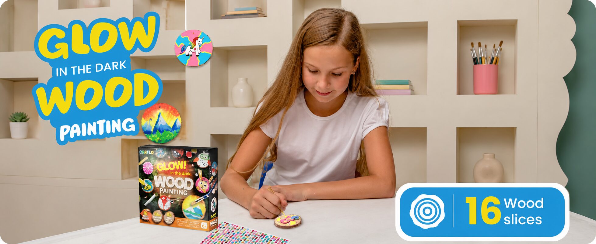 Glow in the dark wood painting: a girl painting a wood slice at a table with the kit box, badged 16 wood slices